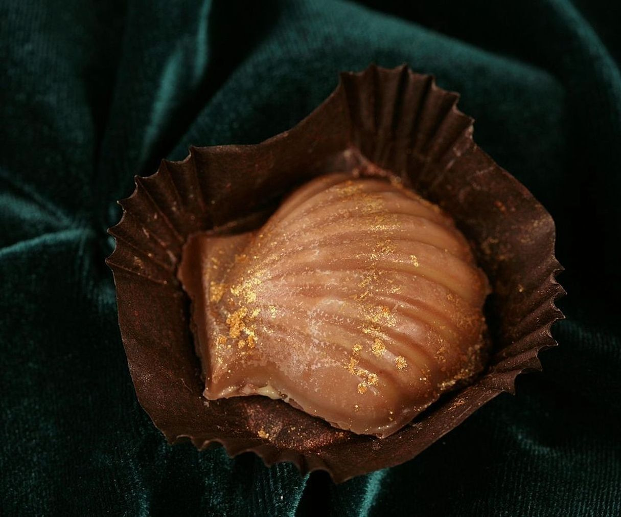 Manos preparando moldes para chocolate sobre la mesada